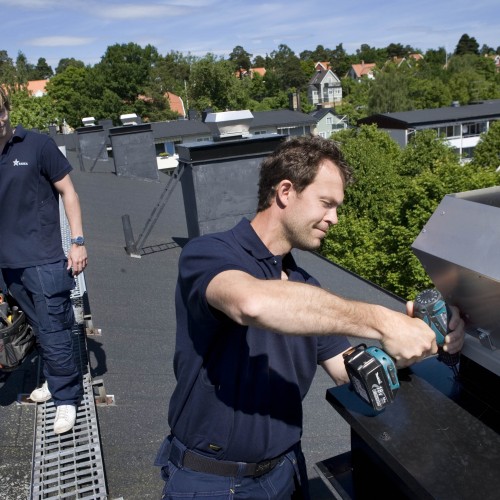 Vår montör Fredrik installerar en takfläkt på ett flerbostadshus